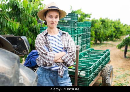 Female farmer posing near tractor on farm Stock Photo