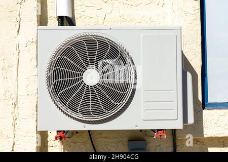 Air conditioner unit outdoor condenser installed on building wall facade. Close up Stock Photo