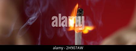 Woman hand holding burning hunting match closeup Stock Photo