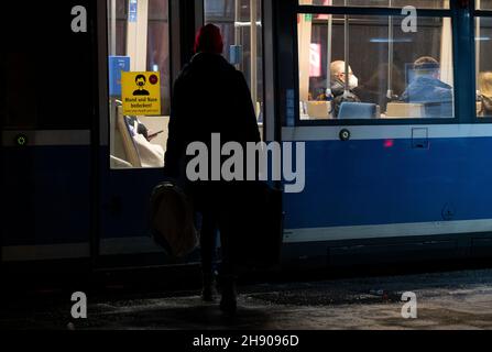 Munich, Germany. 03rd Dec, 2021. A woman gets on a tram at a stop. Credit: Sven Hoppe/dpa/Alamy Live News