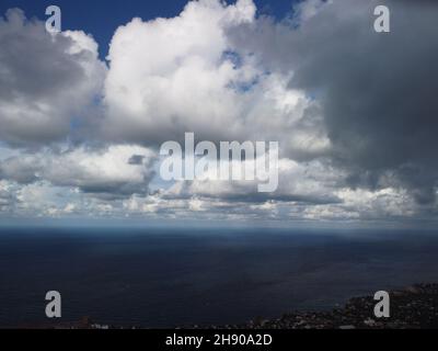 Abstract airy sky with moving plump clouds over the sea ocean. Small waves on clear water surface bokeh lights from sunrise. Holiday, vacation and Stock Photo