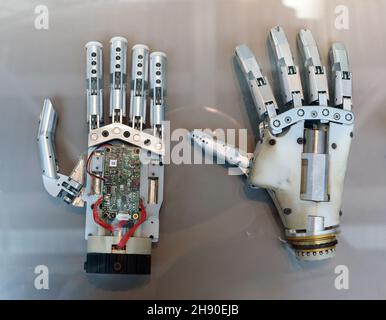 Top view of modern bionic mind controlled robotic prosthetic human hands for amputees placed on gray surface Stock Photo
