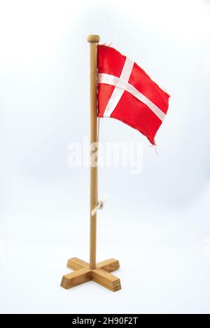 Denmark Flag on Wooden Stick on White Background in Studio. National Symbol of Scandinavian Country as Souvenir.