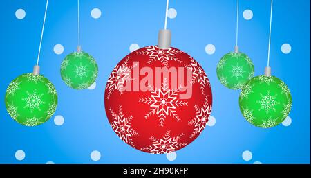 Close-up of red and green baubles hanging from strings against blue background Stock Photo