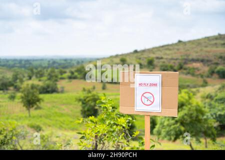 Focus on Sign board, No fly zone Sign board on top of Hill - concept of drone restrictive zones Stock Photo