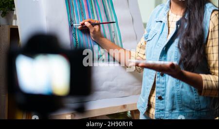 unrecognizable girl artist teaching canvas painting by recording on camera - concept of online teaching, virtual class or education during coronavirus Stock Photo