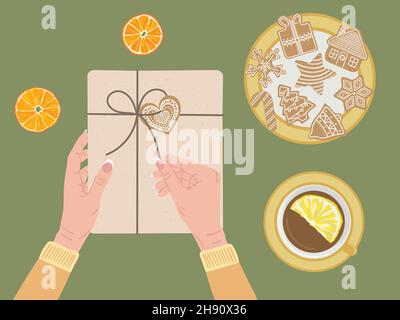 White female hands open gift box wrapped into kraft paper and twine ribbon. Top view dry orange, cinnamon, cup of tea, gingerbread cookies. Eco Christ Stock Vector