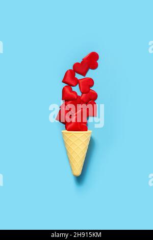 Ice cream cone with red hearts on blue background Stock Photo