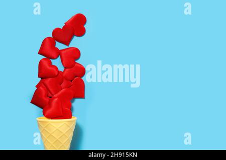 Ice cream cone with red hearts on blue background Stock Photo