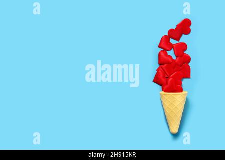Ice cream cone with red hearts on blue background Stock Photo