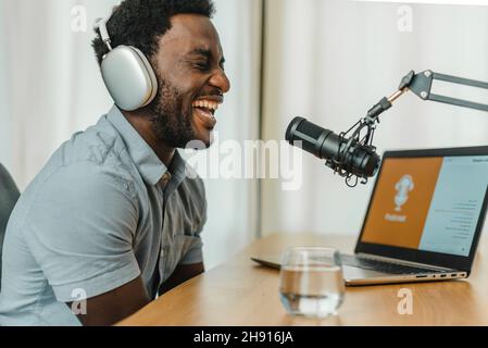 Laughing black man recording podcast Stock Photo