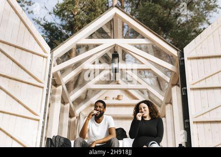 Multiracial couple brushing teeth in morning at hotel Stock Photo