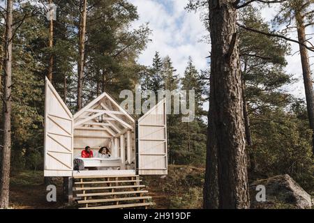 Couple lying on bed in cottage during vacation Stock Photo