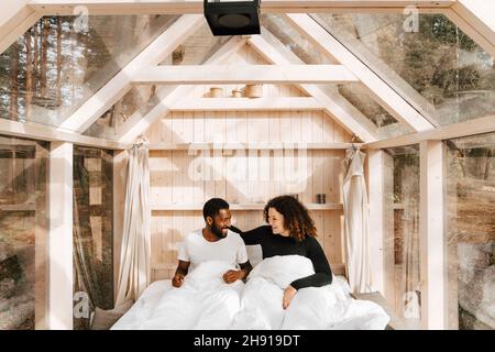 Happy couple looking at each other while waking up in morning Stock Photo