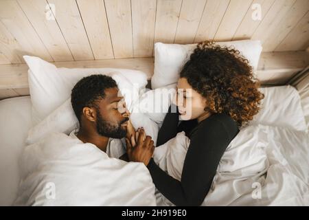 Directly above view of couple sleeping on bed in hotel Stock Photo