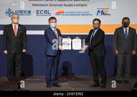 (211203) -- KUALA LUMPUR, Dec. 3, 2021 (Xinhua) -- Darwis Abdul Razak (2nd R), CEO of Malaysia Rail Link, presents document to Kong Qi (2nd L), managing director of China Communications Construction (ECRL), witnessed by Malaysian Transport Minister Wee Ka Siong (1st L) and Chief Minister of Selangor state Amirudin Shari at the ECRL Press Conference and Document Handover Ceremony for Section C (Northern Alignment) in Kuala Lumpur, Malaysia, Dec. 2, 2021. Professionalism and close cooperation of the China Communications Construction Company (CCCC) and its Malaysian partners in the East Coast Rai Stock Photo