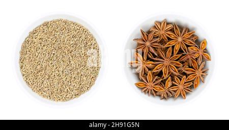 Anise and Star anise fruits and seeds, in white bowls. Pimpinella anisum, also aniseed or anix in the left bowl, and the unrelated llicium verum. Stock Photo