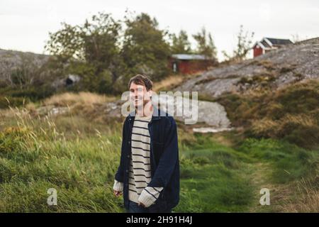 Portrait of cheerful mid adult man standing at island during summer vacation Stock Photo