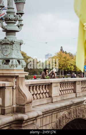 Senior couple photographing while exploring on bridge during vacation Stock Photo