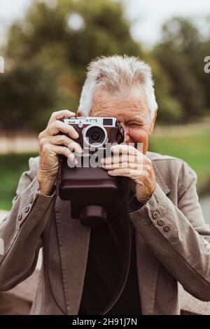 Senior man photographing with camera during weekend Stock Photo