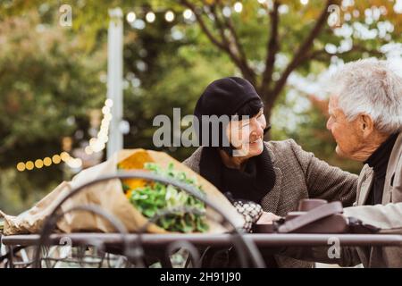 Smiling senior woman looking at man in park during vacation Stock Photo