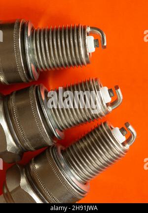 The Car spark plug on orange background. Electric device for machine,Space for design Stock Photo