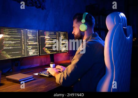 Profile portrait of skilled database tester sit texting typing keyboard earphones song sound night loft space Stock Photo