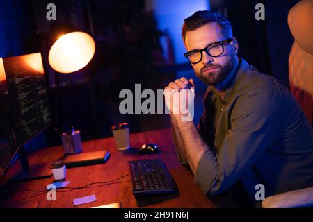 Profile photo of serious skilled person look camera sit chair lamp light dark room business center Stock Photo