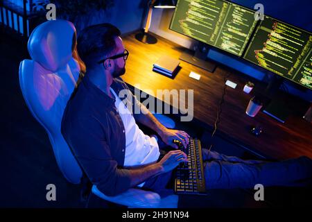 Profile photo of skilled smart guy sit chair typing testing network implementation dark loft space house Stock Photo