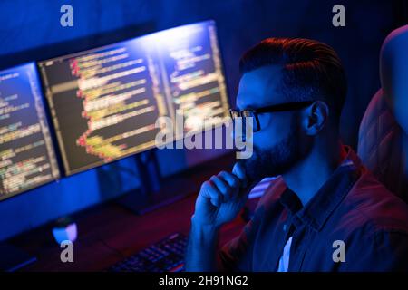 Profile photo of serious minded young person hand on chin ponder dark room business center inside Stock Photo