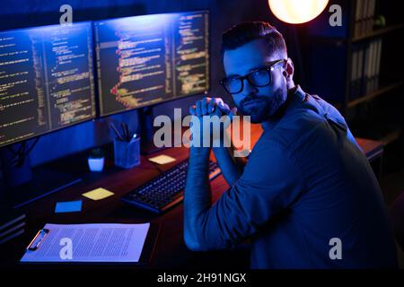 Photo of serious professional programmer look camera improving debugging service experience dark loft space Stock Photo