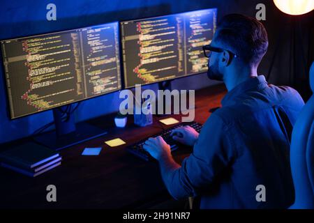 Rear photo of smart skilled introvert tester write typing operating data security evening house dark room Stock Photo