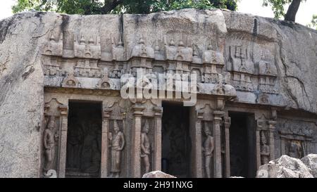 The cave temple is carved in stone and has sculptures and statues. Located on rocky and scenic backgrounds Stock Photo