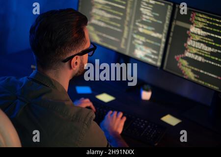 Profile photo of clever young programmer look two monitors optimization html midnight business center Stock Photo