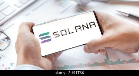 Logo of Solana coin in tablet. Cryptocurrency SOL token. Trading blockchain platform to buy,sell on decentralized exchange DEX,DEFI. Digital money.Bus Stock Photo