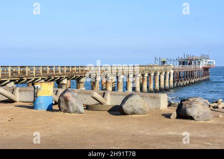 The jetty near the beach of Swakopmund Namibia Southern Africa in the early morning sun at the Atlantic Ocean against a blue sky Stock Photo