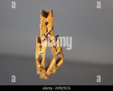 Wooden clothespins on a reflective surface Stock Photo