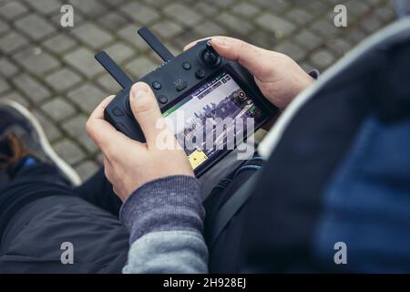 Man holds remote controller of DJI Mavic 2 Pro drone Stock Photo