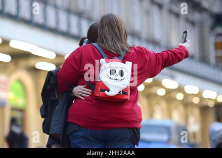 London, England, UK. Two young women taking a selfie with a Jack Skellington Nightmare Before Christas backpack, December 2021 Stock Photo