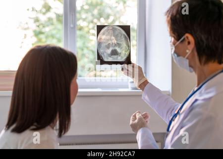 Faceless therapist looking at MRI and consulting patient. XRAY discussion Stock Photo