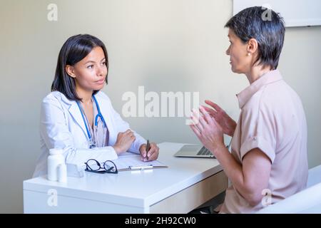 Doctor carefully listening to patient complaints about symptoms at appointment Stock Photo