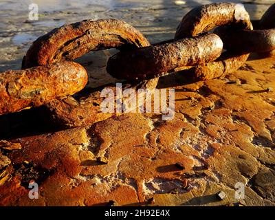 Rusty chain links on concrete Stock Photo