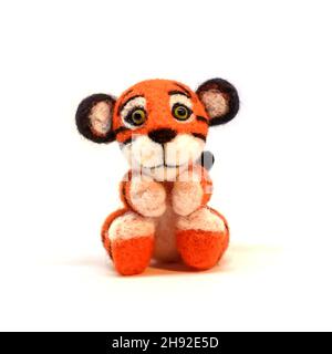 Cute funny little toy handmade woolen tiger, felting from wool, isolate on a white background Stock Photo