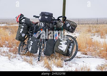 Two heavily laden trekking bicycles with big panniers in the snow in winter, Great Plains, New Mexico, United States / USA Stock Photo