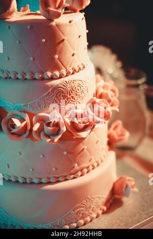 A beautiful brown three-tiered wedding cake with roses. Tasty looking celebration cake. High quality photo Stock Photo