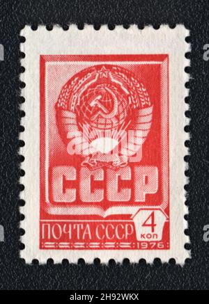 A postage stamp printed in USSR shows Red State Emblem and red flag of the Soviet Union, 1976 Stock Photo