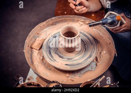 Master class on modeling of clay on a potter's wheel In the pottery workshop Stock Photo