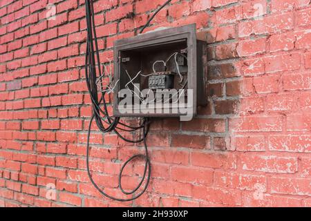 The niche of the old broken electrical panel of the drawer on the wall. Industrial Abandoned Power Control. Stock Photo