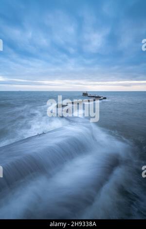 Waves crashing over the iconic zig-zag breakwater at St Monans harbour in the East Neuk of Fife, Scotland, UK.