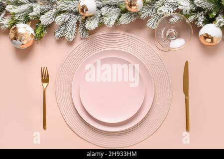 Christmas pink table setting with gold modern decoration and silverware. Holiday dinner party. View from above. Stock Photo